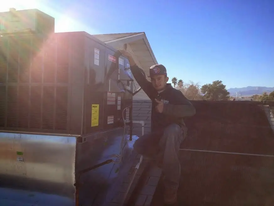 HVAC technician performing AC Tune-Up on a rooftop unit in Old Jamestown